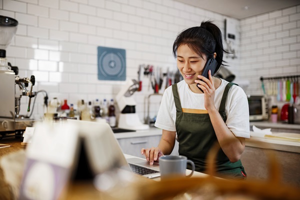 A small business owner taking a call in their cafe