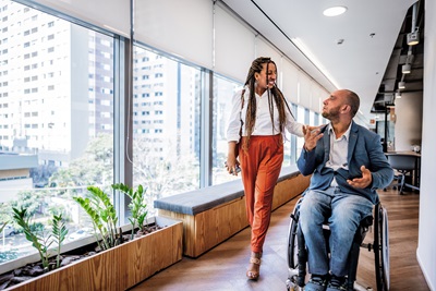 A woman and a man in a wheelchair chatting