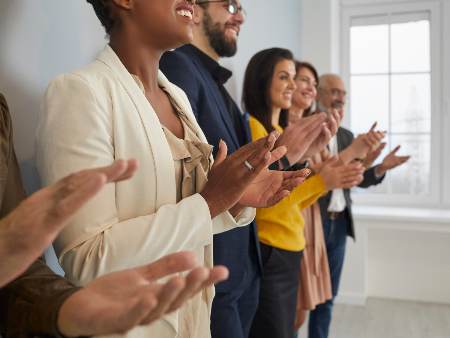A line of coworkers showing appreciation by standing and clapping